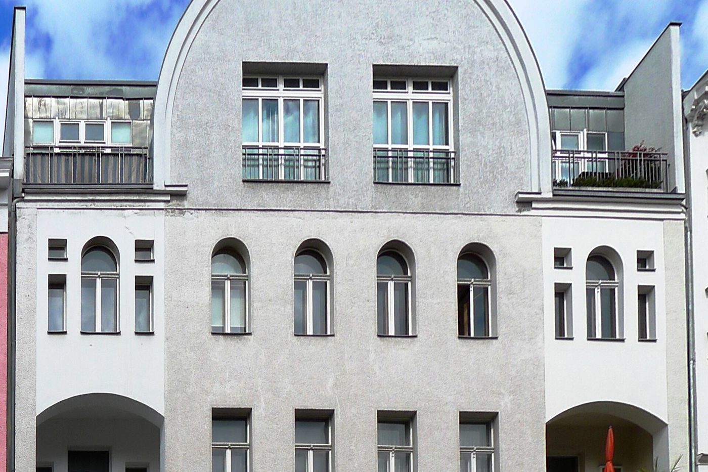 Fassade eines Mehrfamilienhauses mit Bogenfenstern
